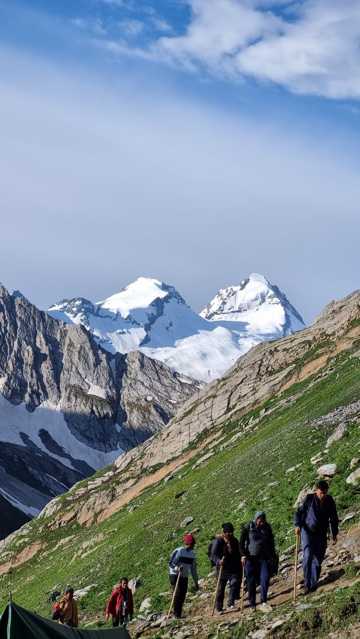 why-choose-us Hikers traverse scenic Jammu landscape with snow-capped peaks. Adventure and nature at its finest.