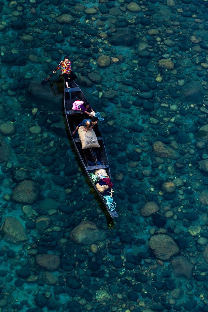 services-02 Beautiful aerial shot of a wooden boat navigating clear river waters. Perfect for travel or nature themes.